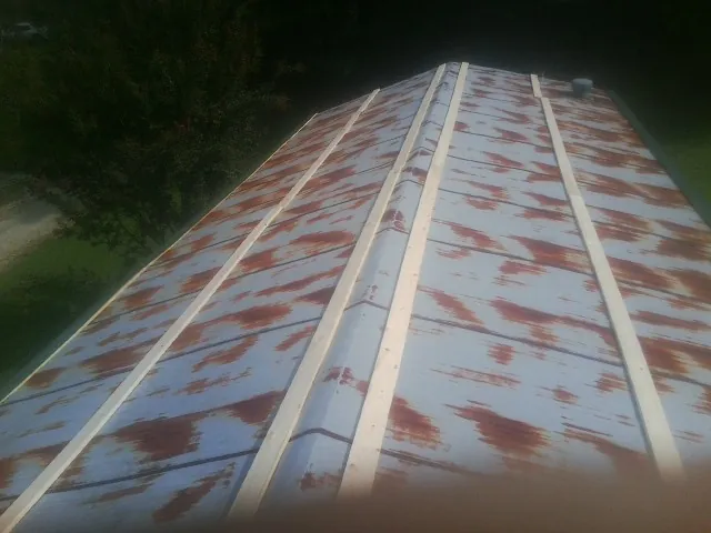 Rusted metal roof panels with new wood purlins before replacement — Storm Damage Roof Repair in Monee by Roofing Brothers